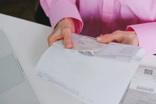 Business person handling paper receipts, meticulously organized.